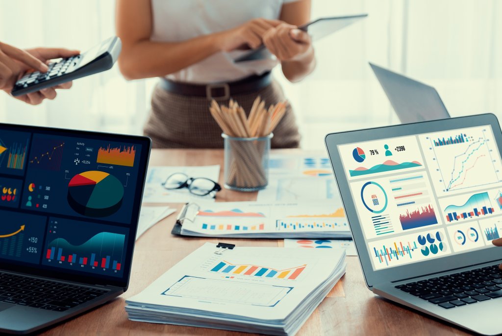 Personer som sitter och jobbar framför datorskärm som visar på olika visualiseringar av data i grafer, tabeller, diagram.