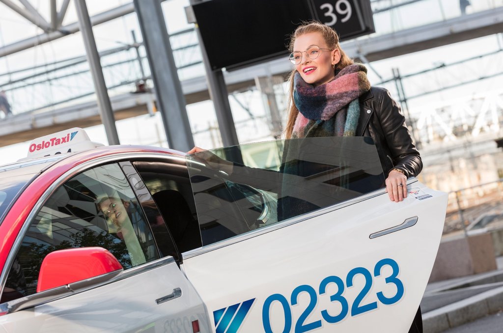 Bilde tatt av Oslo Taxi av en kvinne som entrer en taxi 