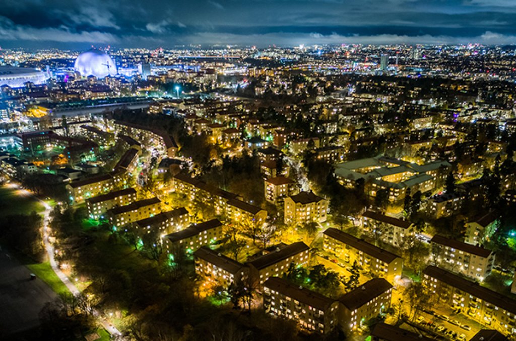 Flygfoto som visar hur en stor del av Stockholm, inklusive Globen, är el-upplyst i mörkret. Symboliserar hur viktig strömmen är i och för staden. 