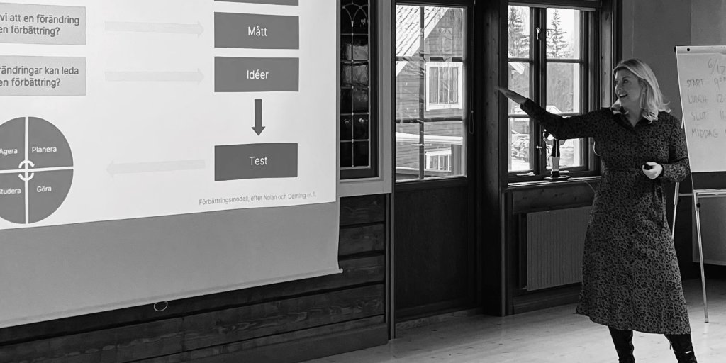 Svartvit bild på kursledaren Karin Evenholt vid ett utbildningstillfälle i systematiskt förbättringsarbete